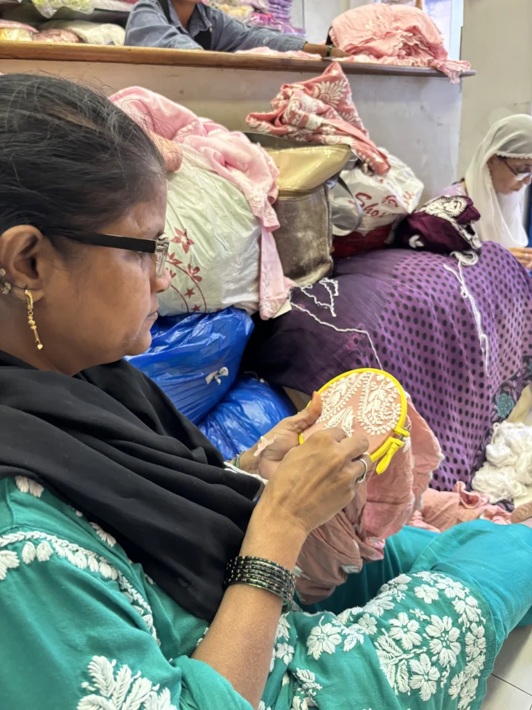 Close-up of an artisan stitching Chikankari embroidery by hand on a hoop