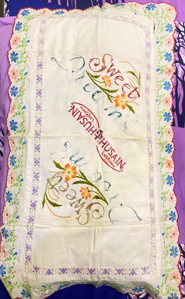 Heritage hand-embroidered cushion cover with floral Chikankari border and the Husain family name stitched in red